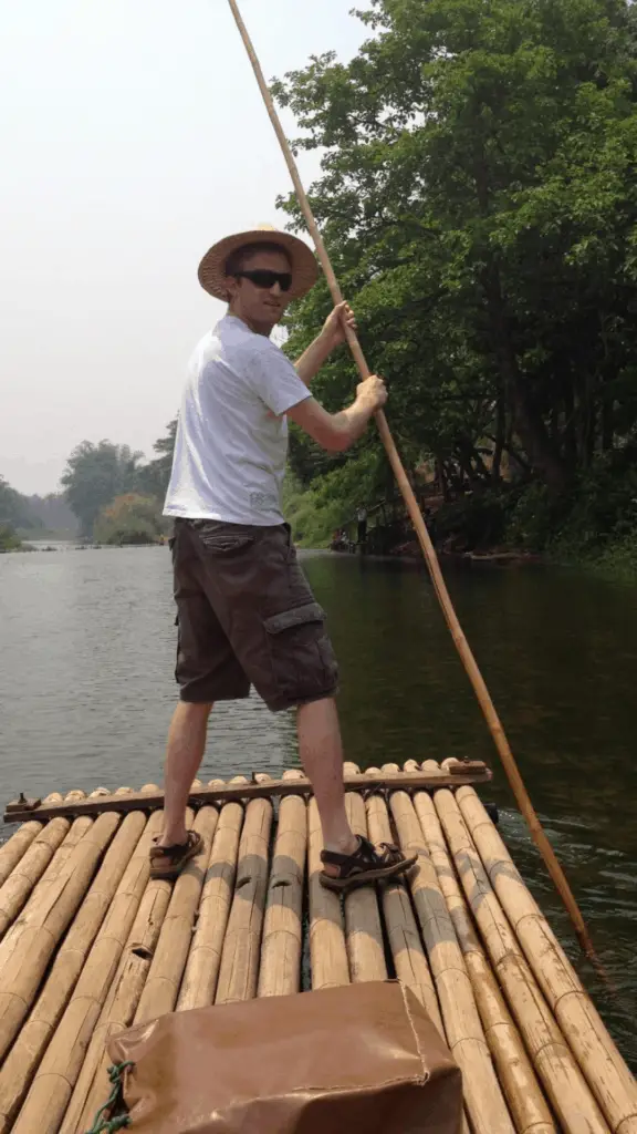 living in Thailand with James on a bamboo raft going down a river
